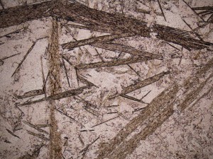 Coarse platy calcite crystals are accompanied by interstitial quartz and fine adularia rhombs. Plane polarised light, field of view = 3.0 mm.